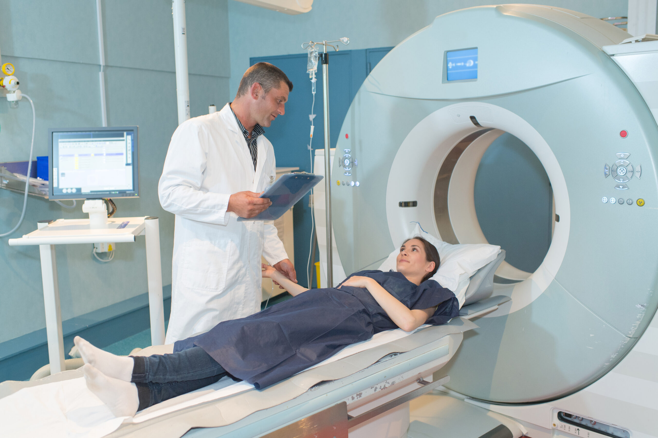 attractive smiling doctor preparing man for scanning in mri machine